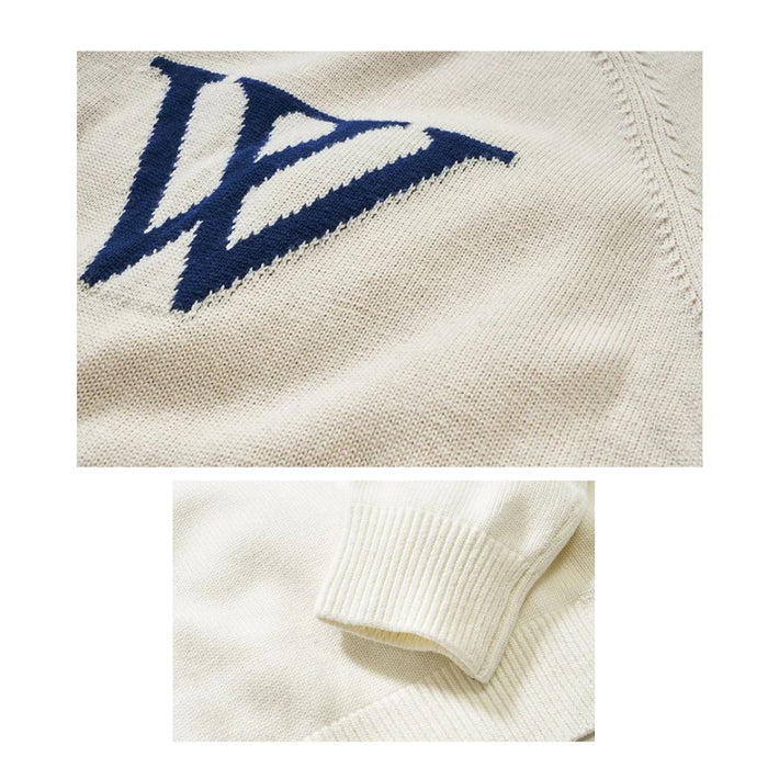 Close-up detail of navy W embroidery on cream jacquard knit jumper