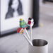 White pencils with Santa, tree and snowman eraser toppers in a pot